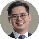 Smiling man wearing glasses and a suit.